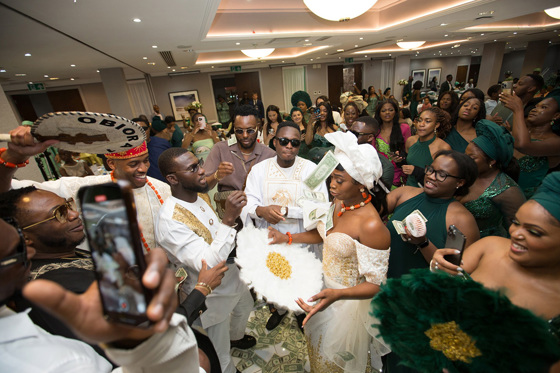 Guests film bride and throw money at her in Nigerian wedding tradition